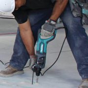 Man using a Makita Hammer Drill on concrete